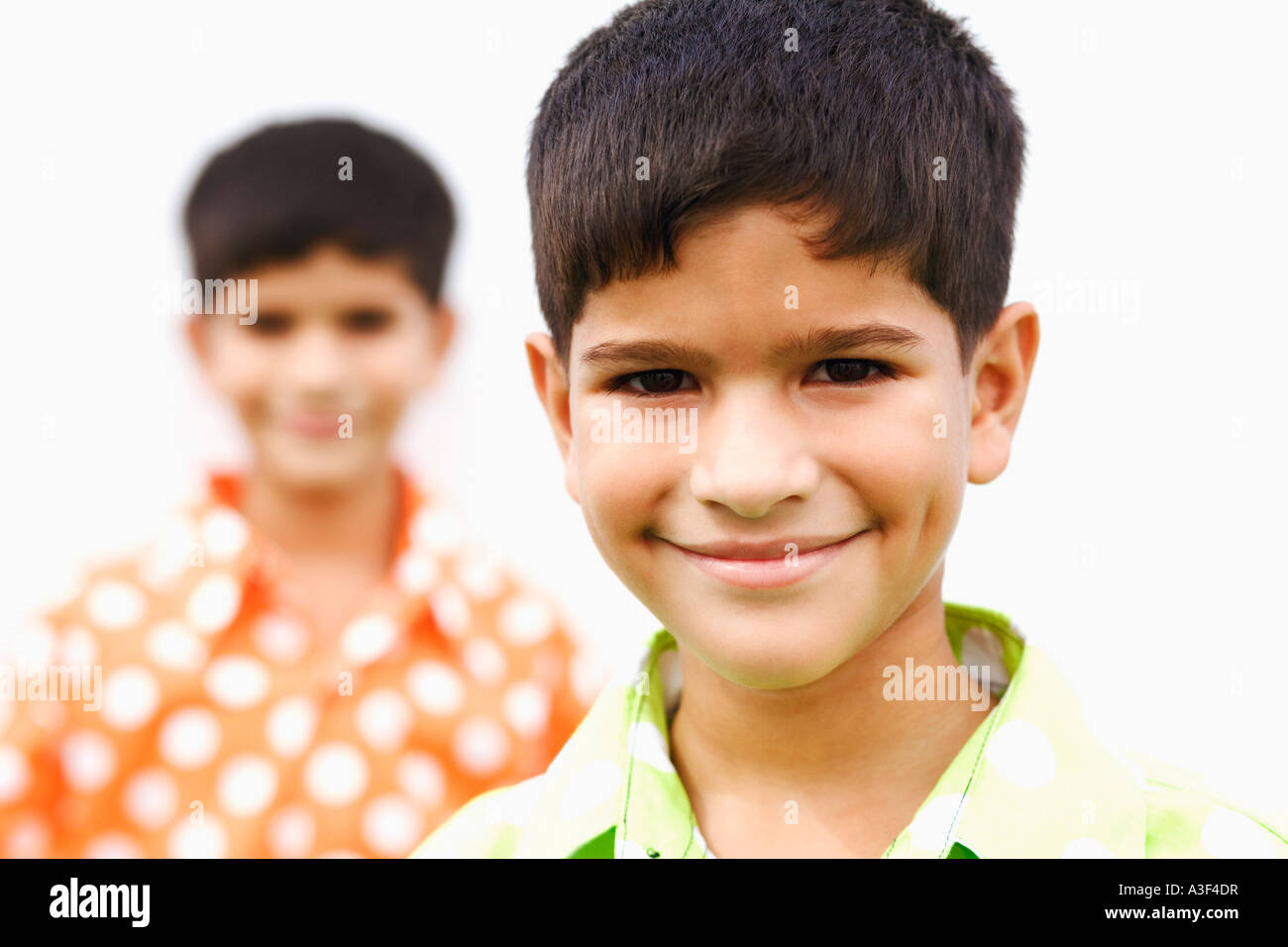 Ritratto di un ragazzo smirking con suo fratello in background Foto Stock