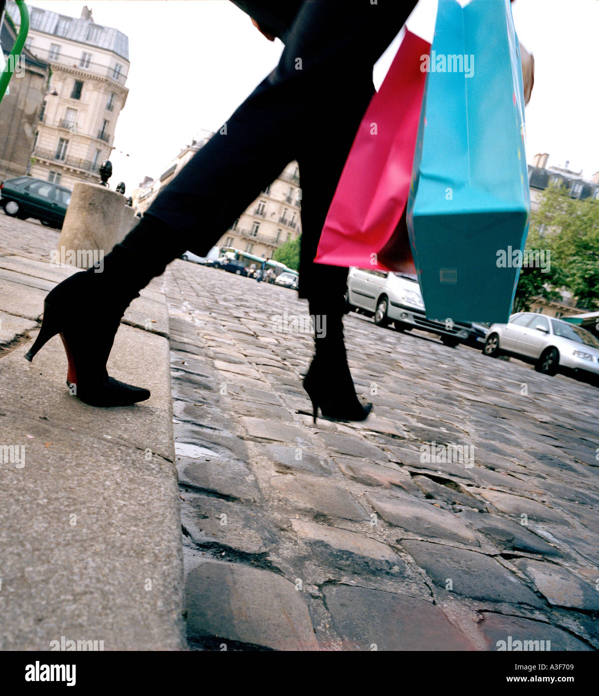 Donna passo fuori da frenare in Parigi con borse per lo shopping Foto Stock