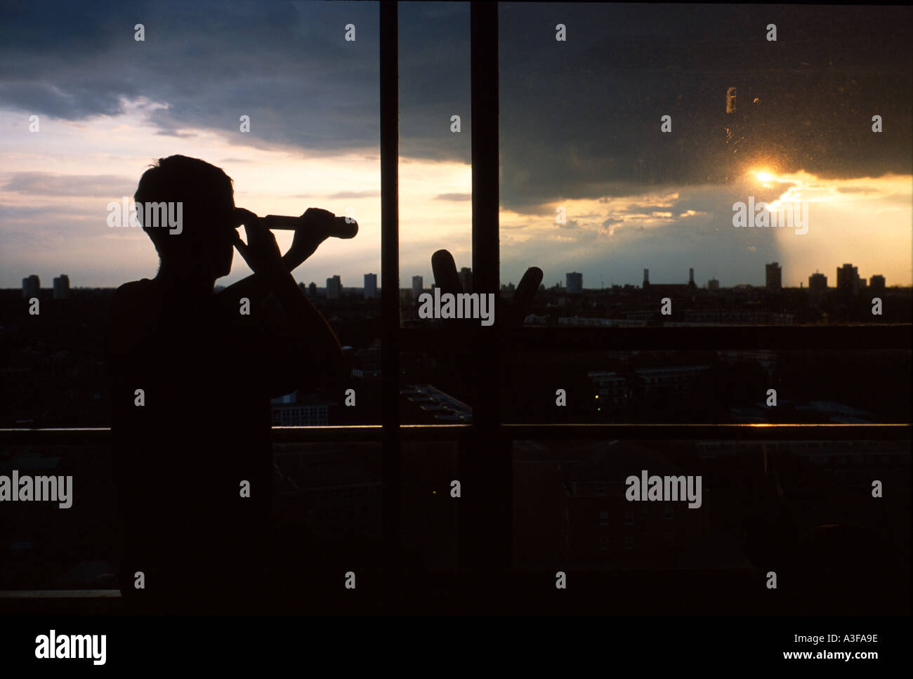 Silhouette di un uomo che guarda con un monocolo al di fuori della finestra di Londra Foto Stock