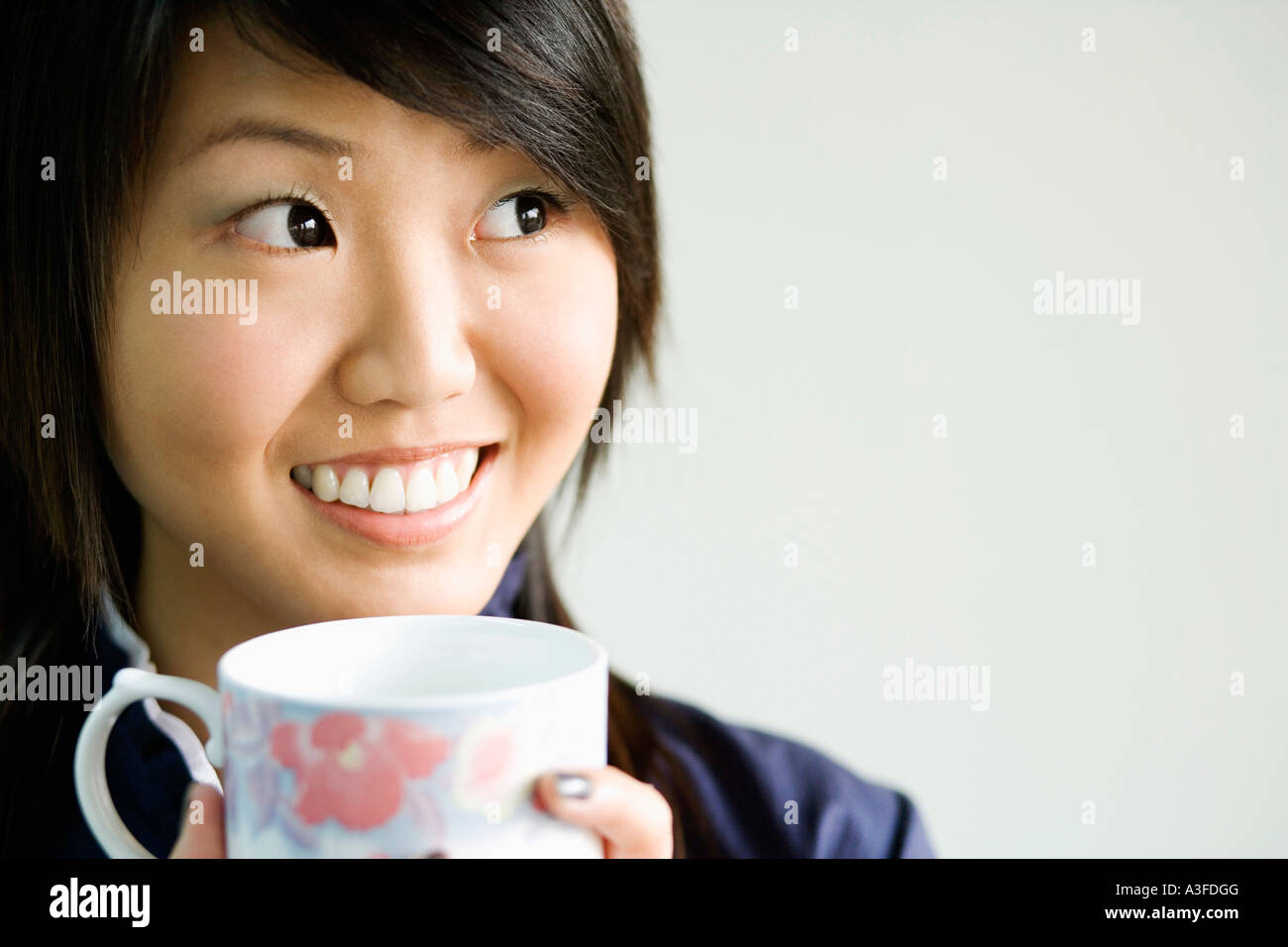 Close-up di una giovane donna che mantiene una tazza di tè Foto Stock