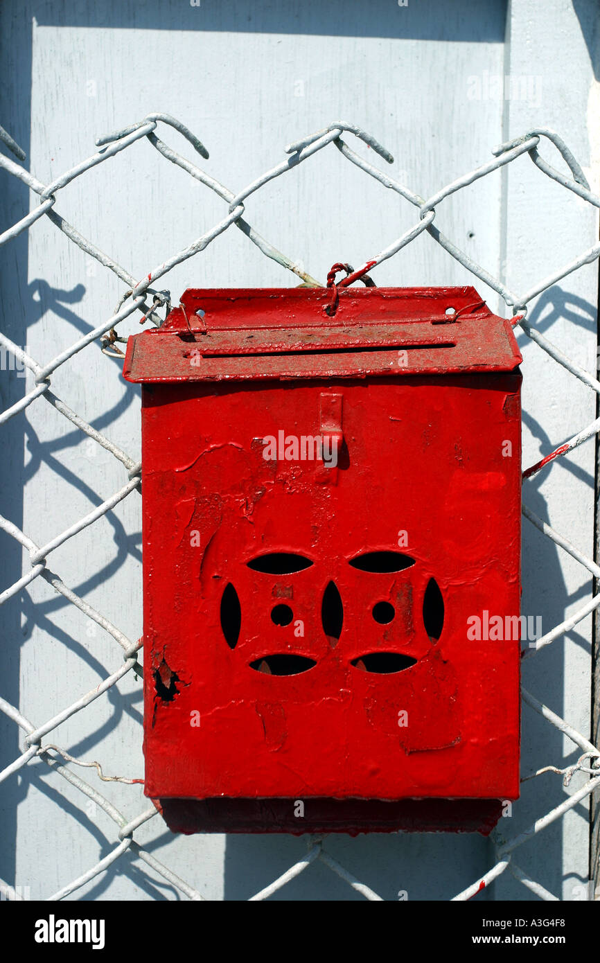 Cassetta postale di ferro rosso vecchio muro verde filo netting maglie reticolati di filo spinato Foto Stock