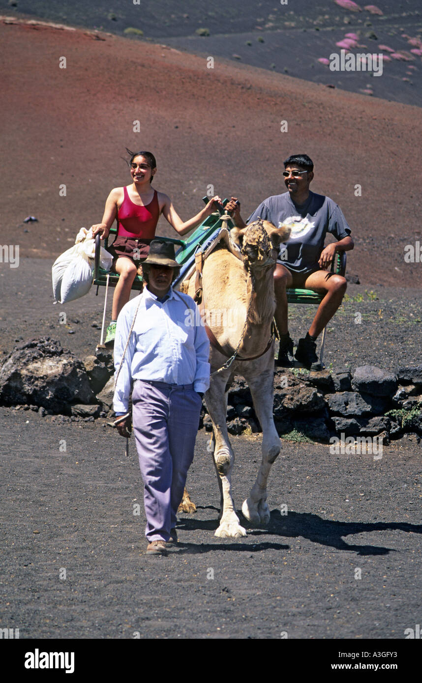 I turisti con la guida sulla corsa in cammello Timanfaya Lanzarote isole Canarie Spagna Foto Stock