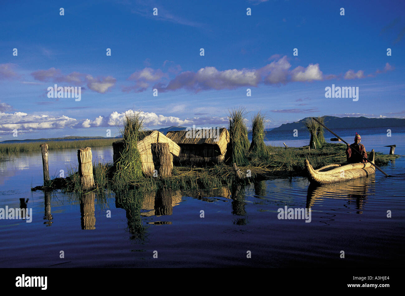 Uomo di uros tribù riding totora reed barca a sera isola galleggiante realizzato da totora reed lago Titicaca Perù Bolivia Foto Stock