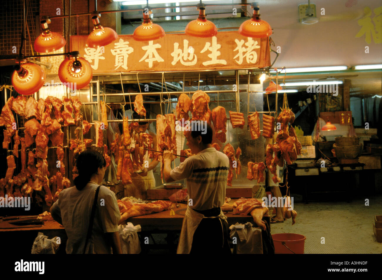 Butcher nella sala mercato città di hong kong cina Foto Stock