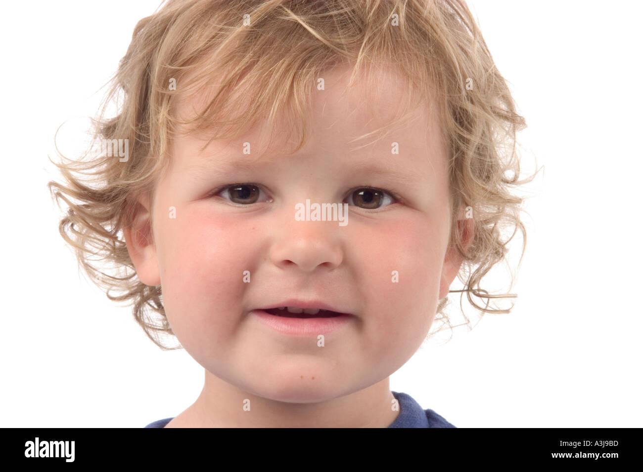 Un bambino piccolo con capelli ricci sorridente Foto Stock