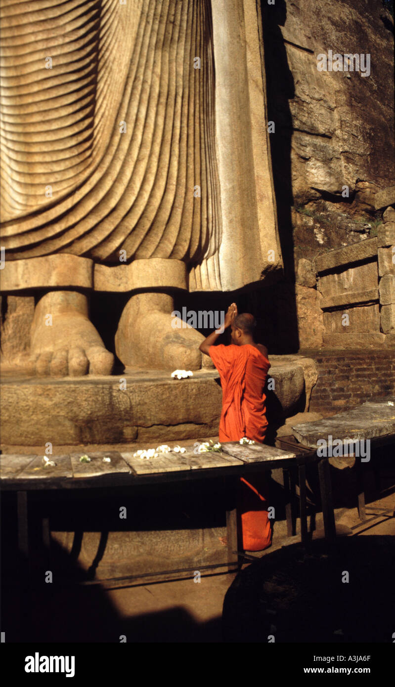 Un monaco prega il Aukana Buddha in Sri Lanka Foto Stock
