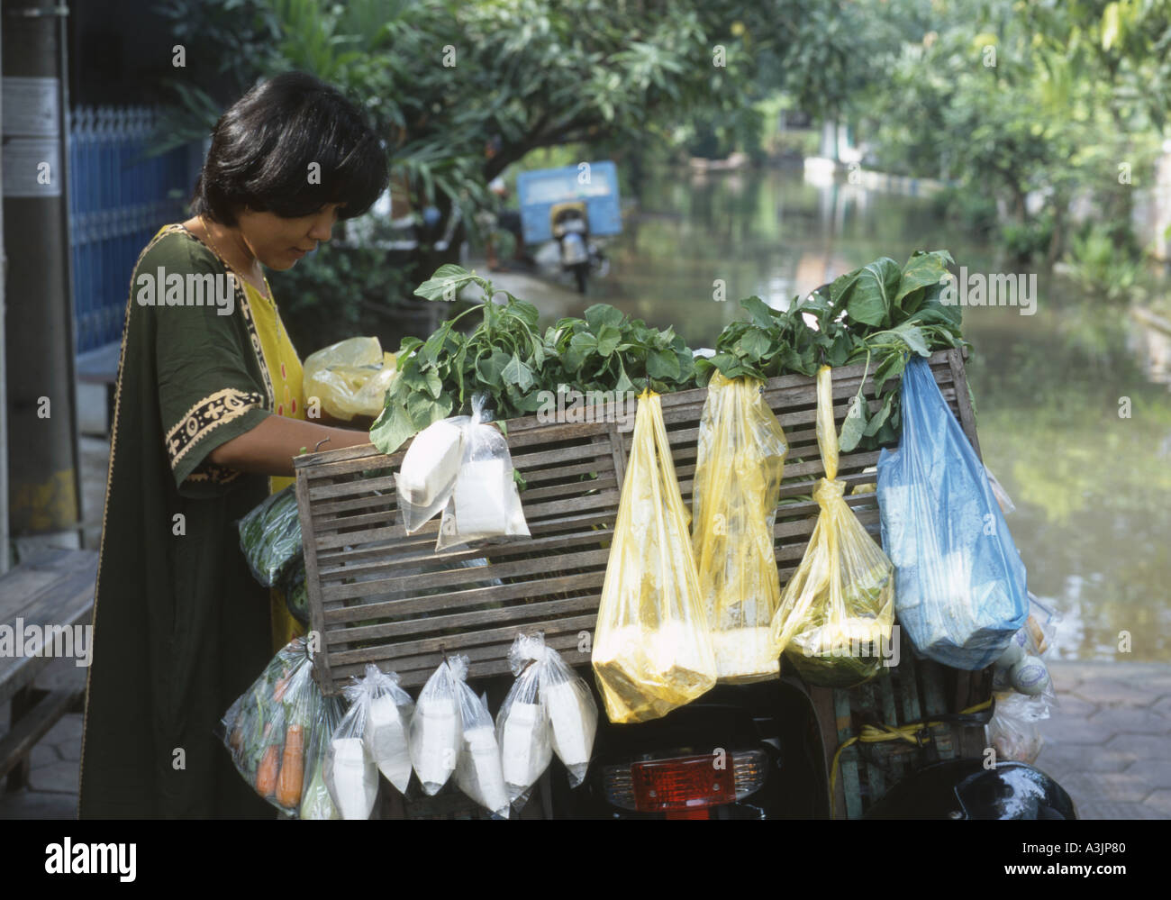 Donna locale prepara il suo cibo carrello nelle strade inondate di trosobo vicino a Surabaya indonesia java Foto Stock