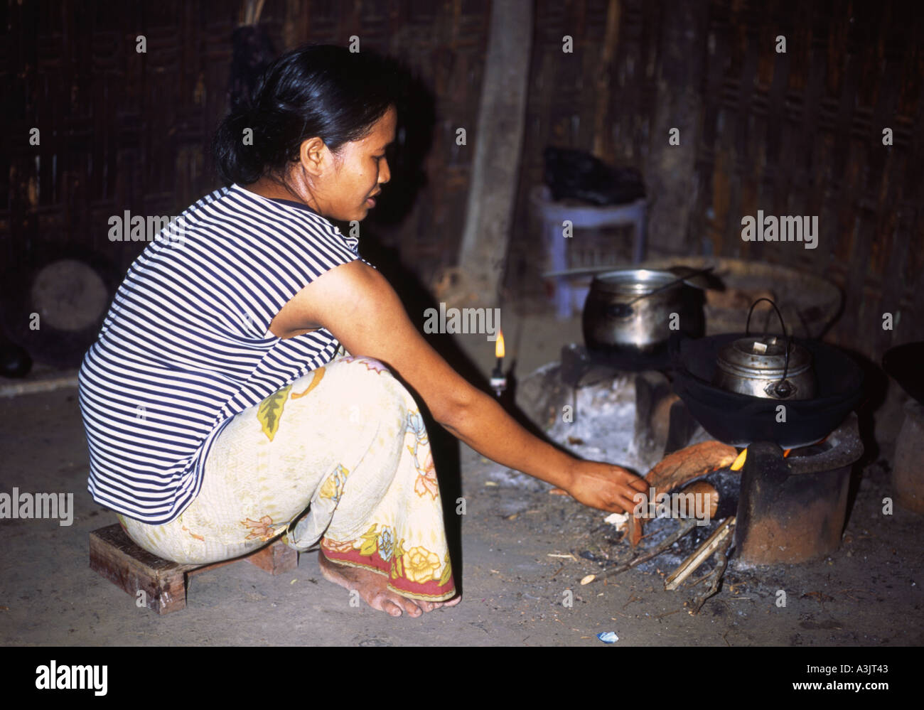 Villaggio locale cucina donna su un fuoco aperto nel poco conosciuto villaggio Sasak del Sud Segenter Lombok Indonesia Foto Stock