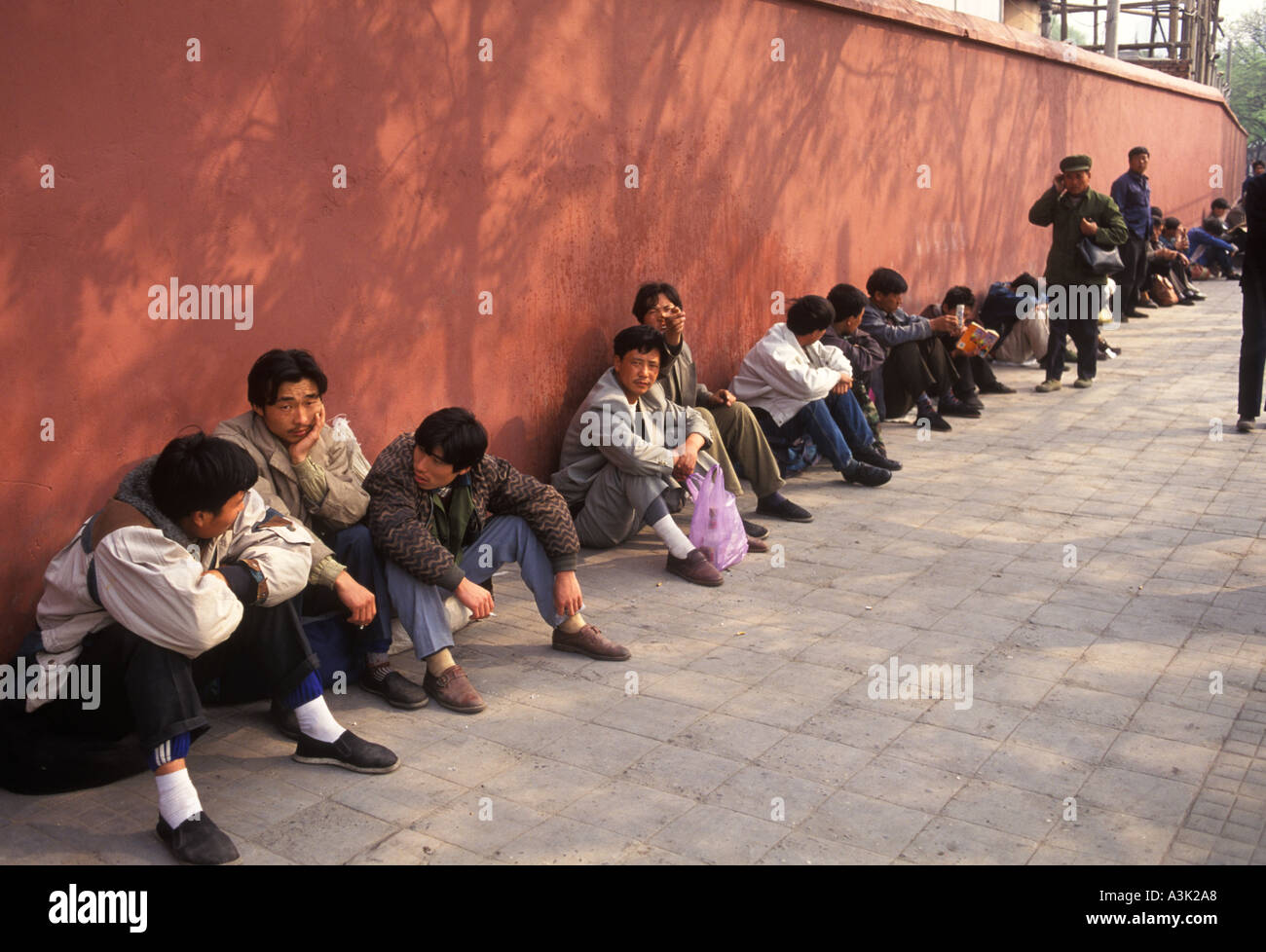 Pechino Cina Economia 1990s. Uomini disoccupati in un mercato del lavoro informale quotidiano. Non riconosciuto dal governo locale 1998 OMERO SYKES Foto Stock