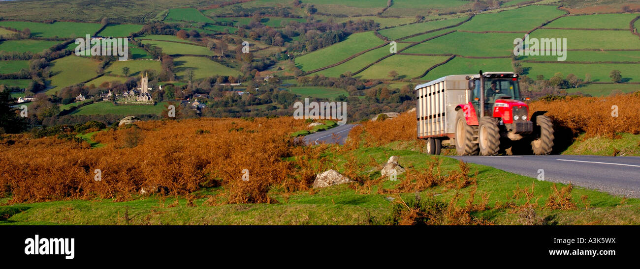 Panoramica scena Dartmoor affacciato Widecombe in moro con colore rosso brillante lentamente il trattore scoppiettamento fino alla collina Foto Stock