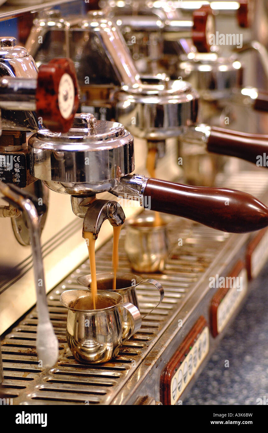 Il caffè fresco versando da una macchina espresso Foto Stock