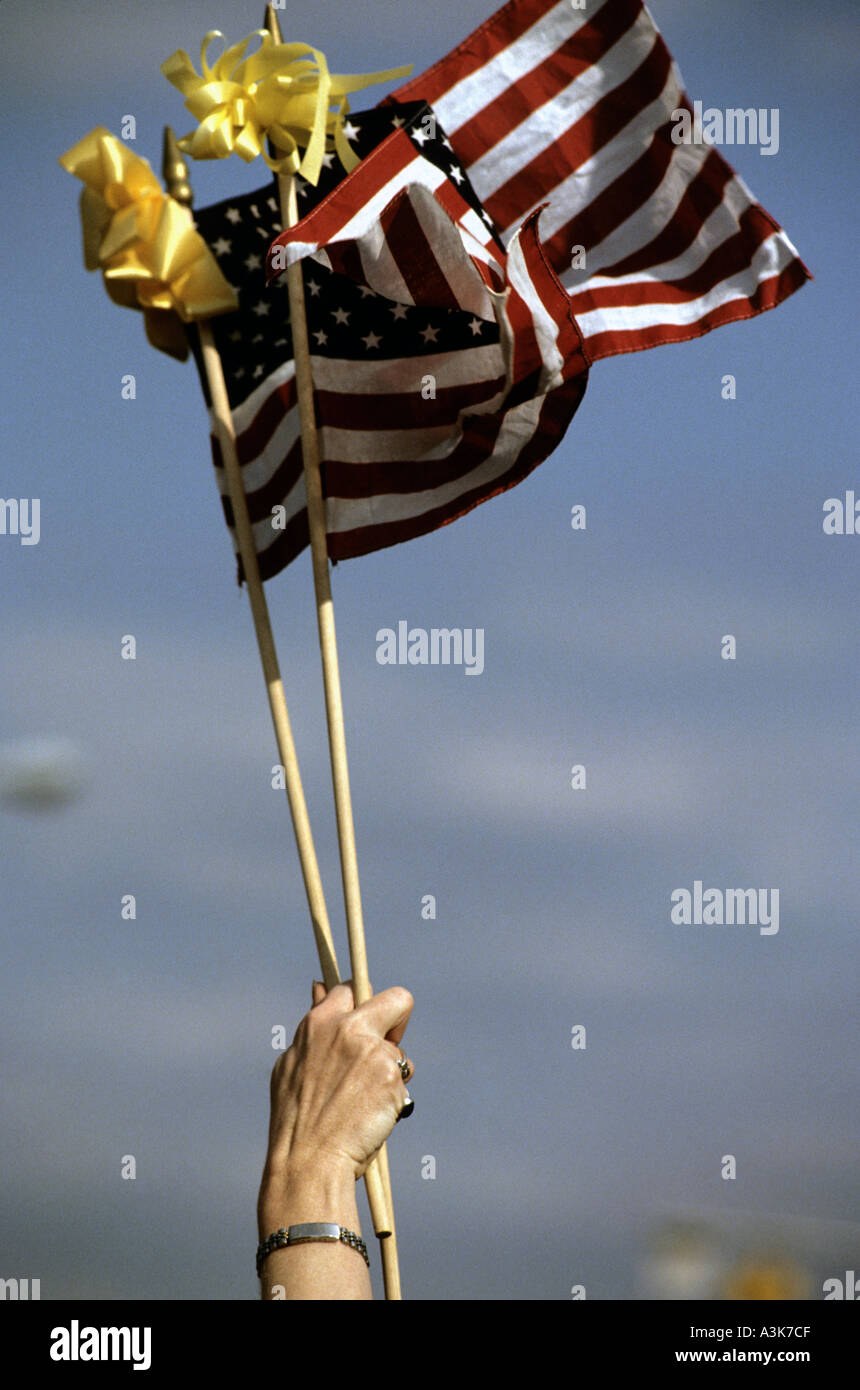Una donna si solleva due bandierine americane durante una cerimonia di premiazione che si terrà a Fort Bragg nella Carolina del Nord STATI UNITI D'AMERICA Foto Stock