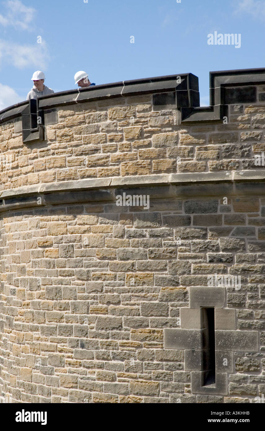 Due lavoratori edili Indossare copricapi rigidi sulla sommità di una torre al Castello di Edimburgo in Scozia UK Foto Stock