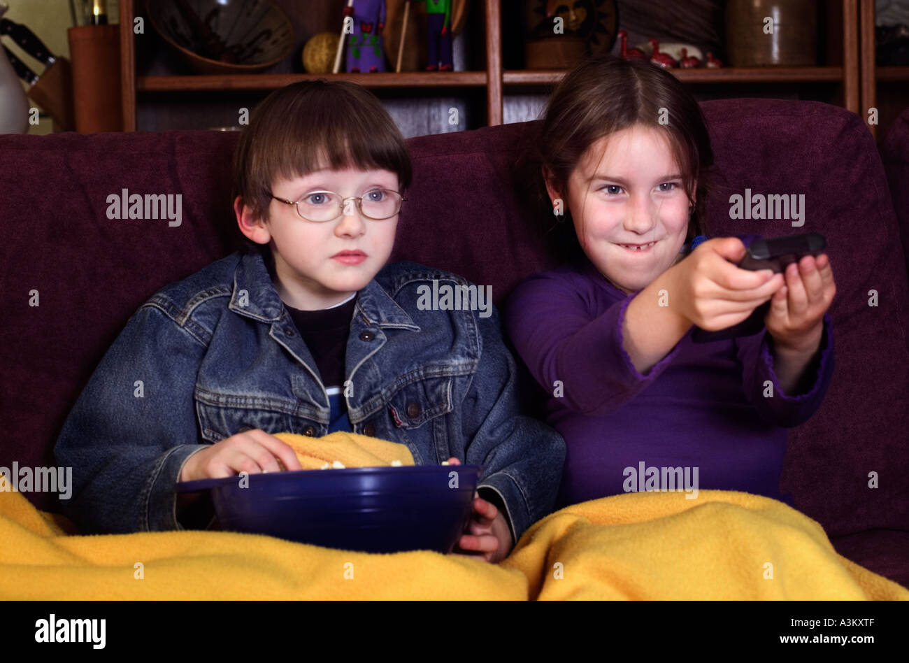 Kids guarda il filmato sul televisore e mangiare popcorn Foto Stock