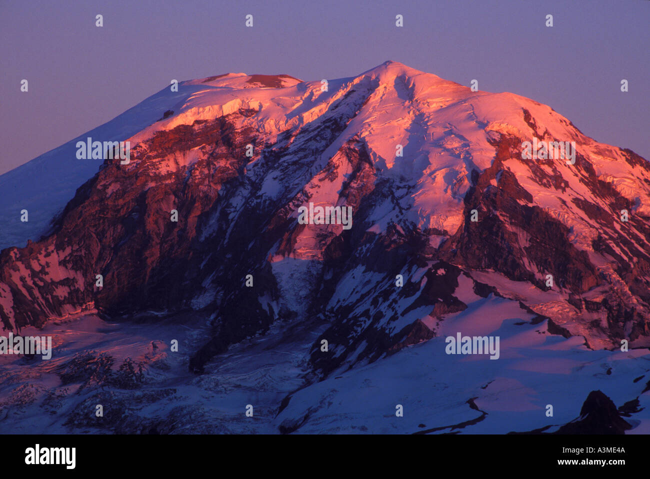 Sera alpenglow sul Monte Rainier dal vertice di cui sopra il lago nel deserto di Clearwater Washington Foto Stock