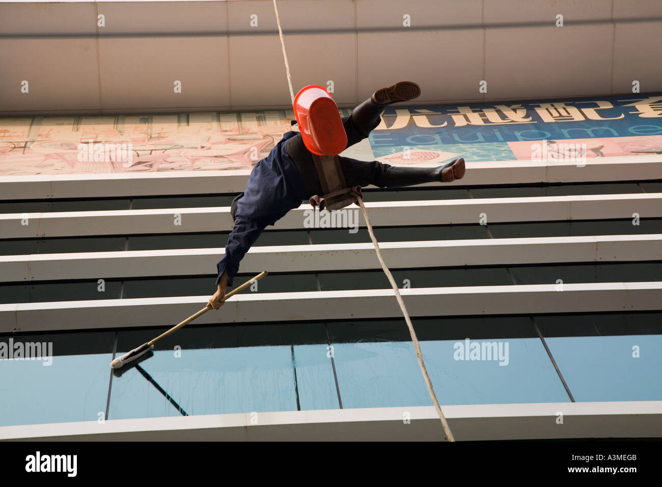 Pulizia finestrino pendente da una corda in Guangzhou - Cina meridionale. Foto Stock