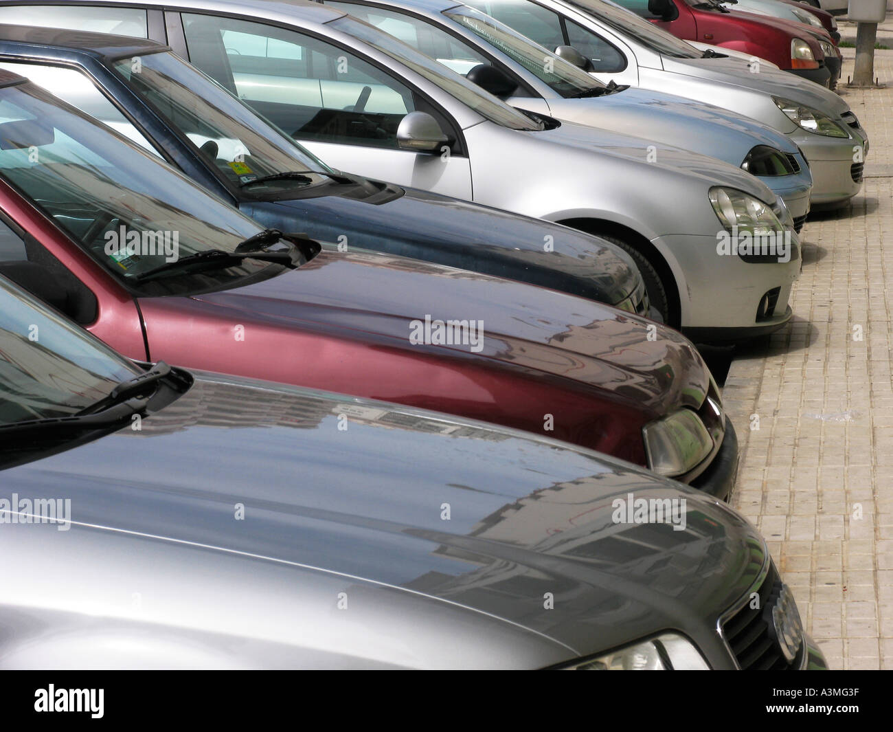 Linea di automobili parcheggiate in strada di città Foto Stock