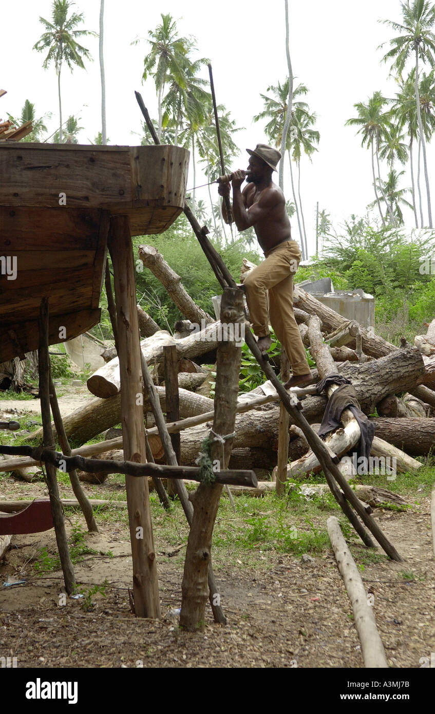 Uomo al lavoro la costruzione di una dhow Zanzibar Foto Stock