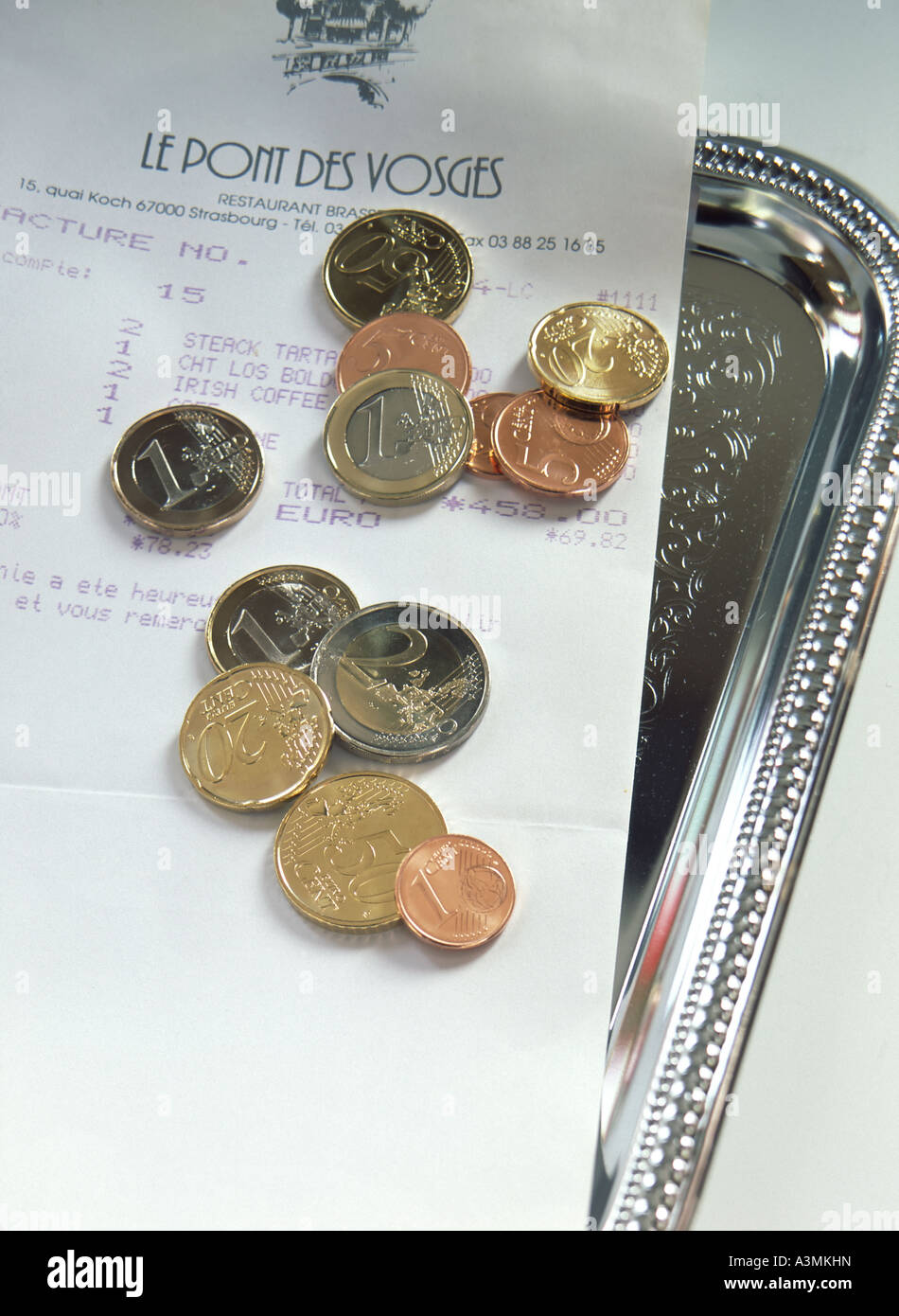BOLLETTA DEL RISTORANTE E MONETE IN EURO SUL VASSOIO DELLE PUNTE FRANCIA EUROPA Foto Stock