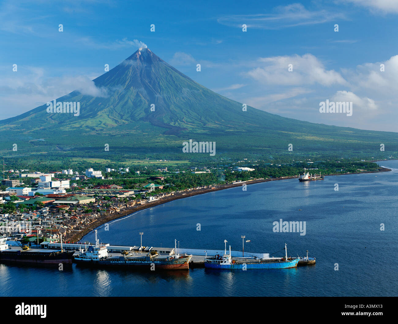 La città di Legazpi con il monte Mayon, il vulcano più attivo delle Filippine, che sovrastante, a Luzon, nelle Filippine. Foto Stock