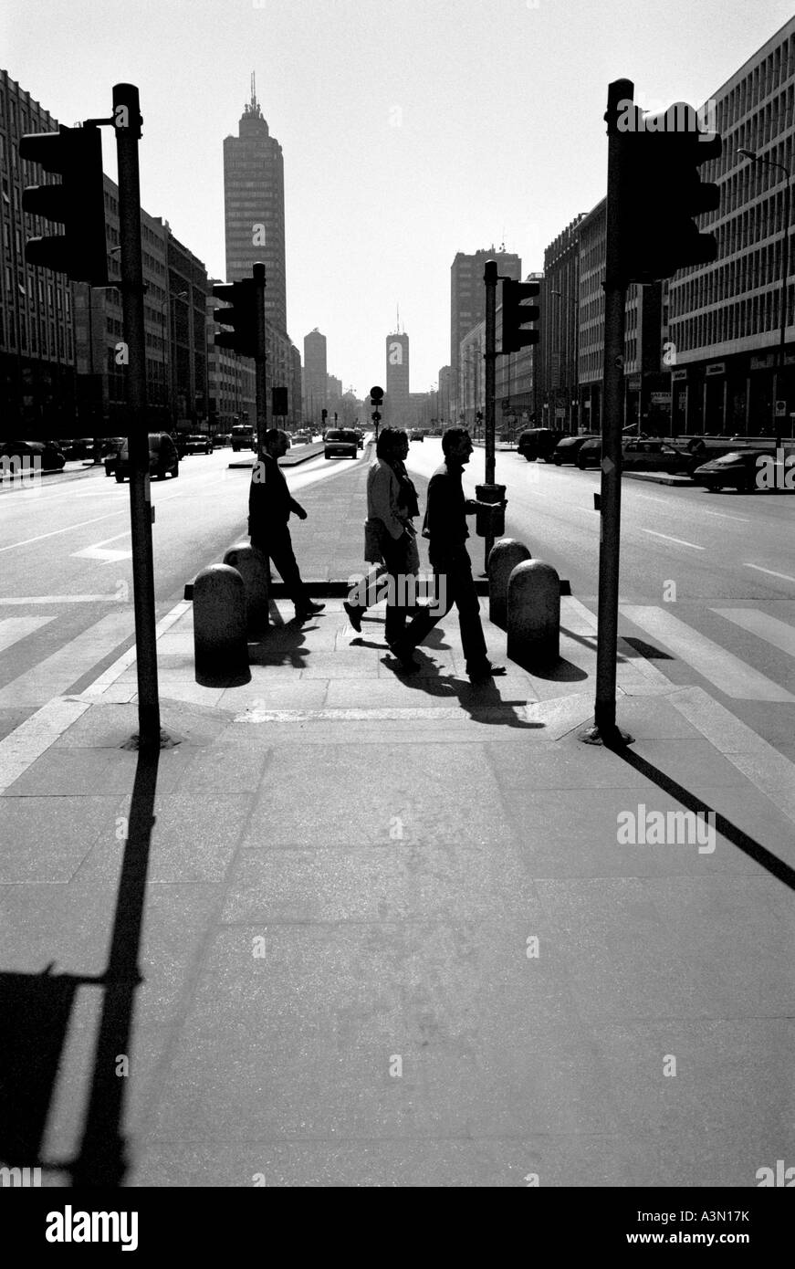 Persone retroilluminate che attraversano Via Vittor Pisani nel centro di Milano Foto Stock