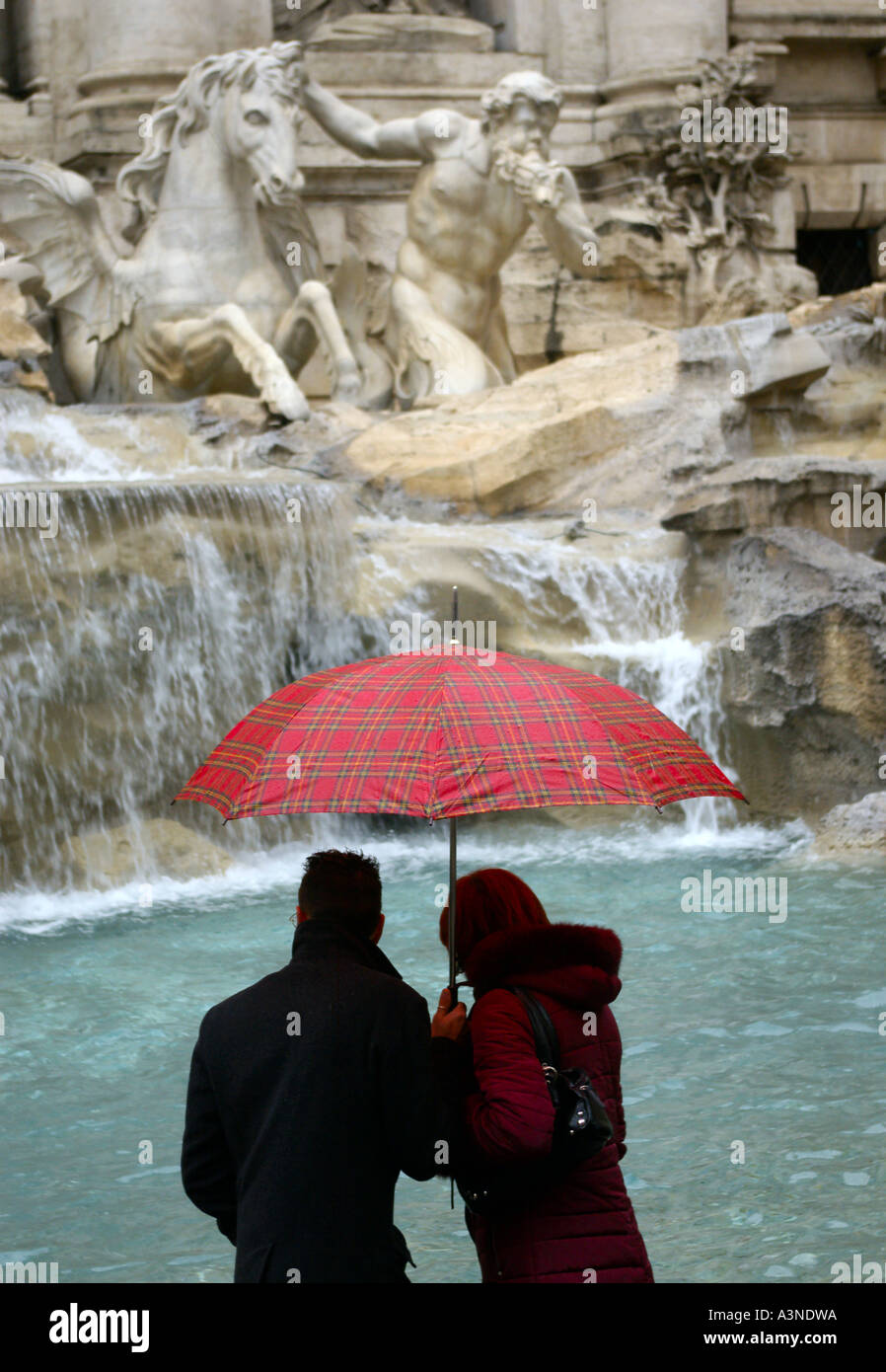 Una coppia romantica weekend a Roma l'Europa con un ombrello di gettare una moneta e che desiderano nella fontana di Trevi Roma, Italia, Europa Foto Stock