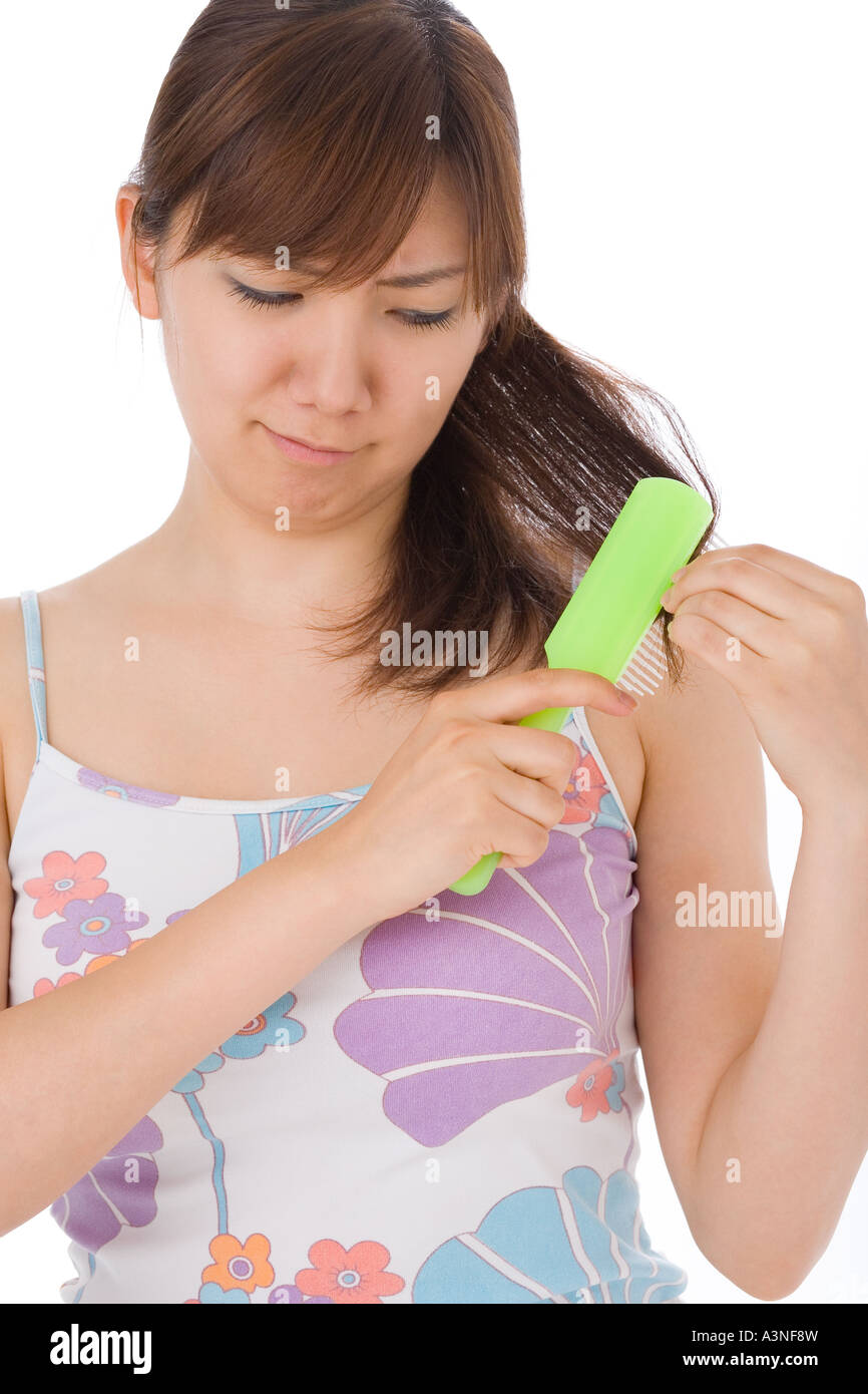 Una giovane donna capelli di spazzolatura Foto Stock