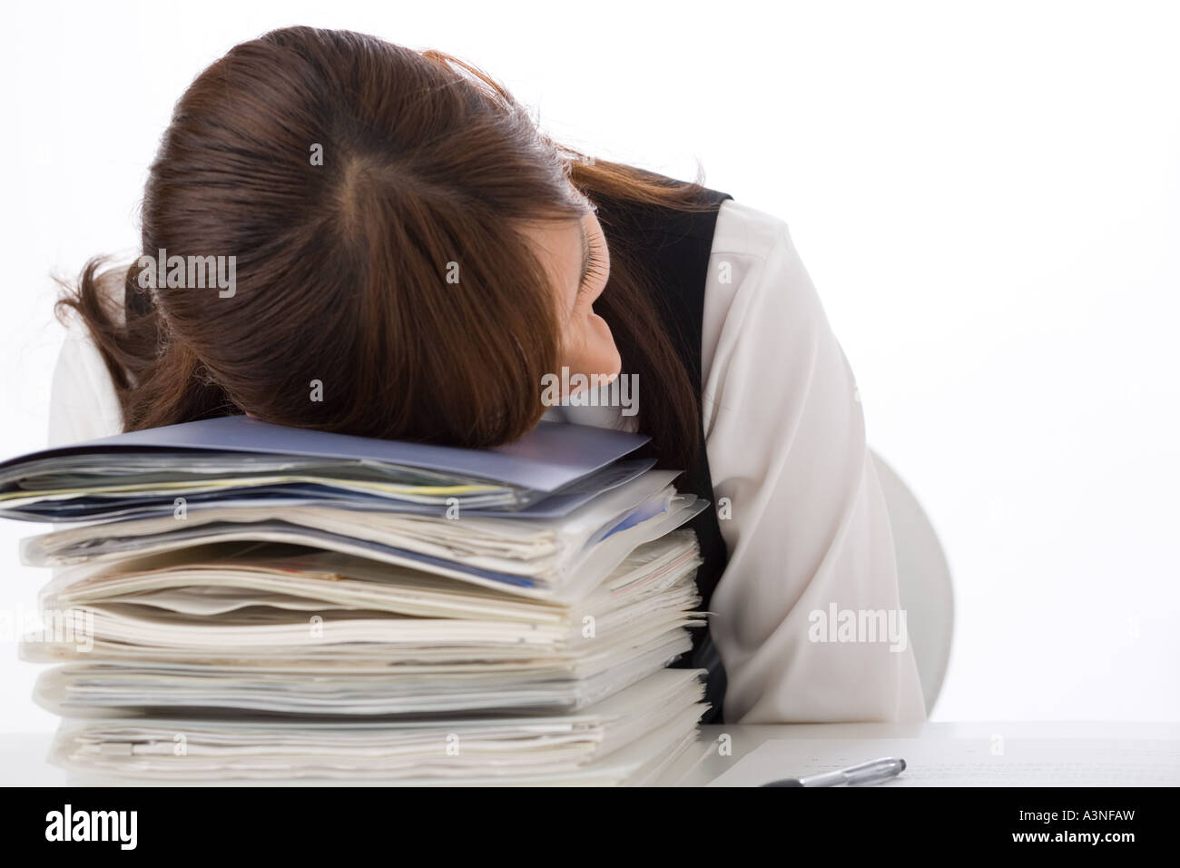 Una giovane donna che dorme alla sua scrivania Foto Stock