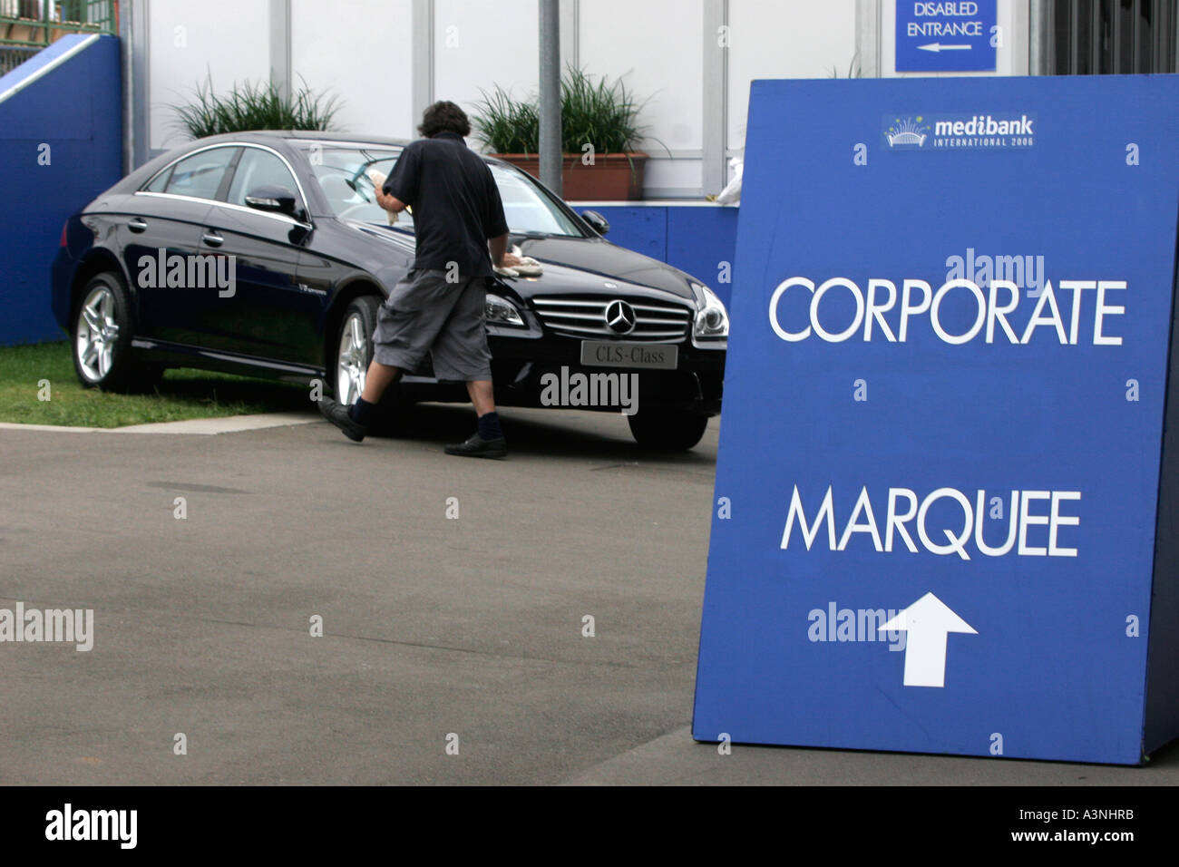 Un giovane uomo leviga il modello più recente Mercedes Benz a un evento sportivo la società sponsor Foto Stock