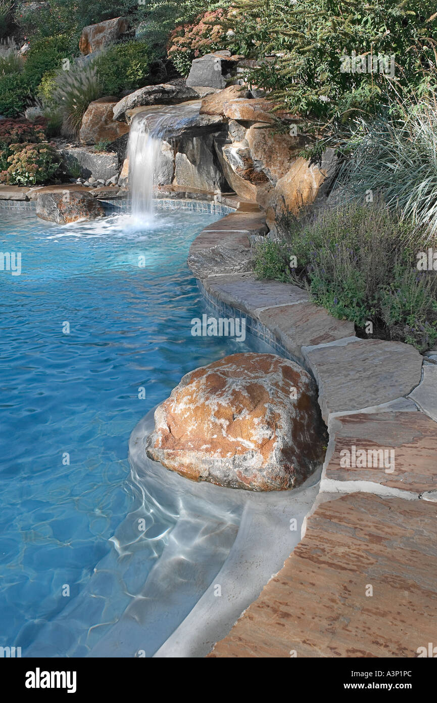 Costoso Backyard piscina con cascata Foto Stock