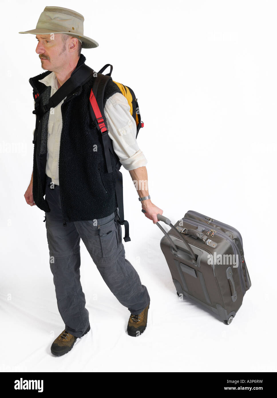 Viaggiatore maschio tirando i bagagli e zaino porta su sfondo bianco Foto Stock