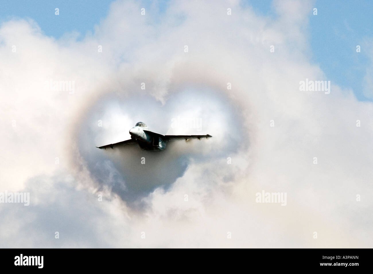 Un U.S. Navy F/A-18 Hornet forma le nuvole di vapore di San Valentino su una alta velocità Pass Foto Stock