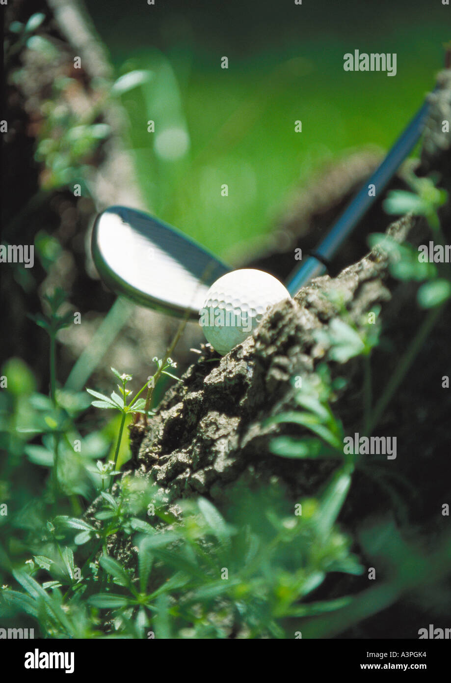 Club accanto a pallina da golf nel fango, close-up Foto Stock