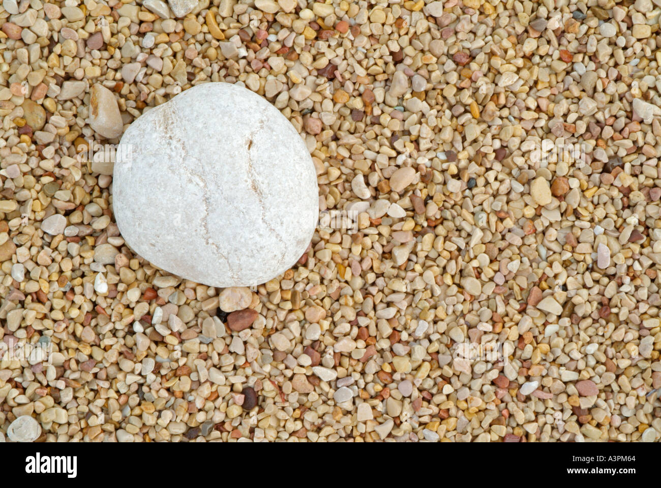 Una piccola ghiaia bianca in una massa di piccoli ciottoli colorati su una spiaggia in una configurazione astratta Portogallo UE Foto Stock