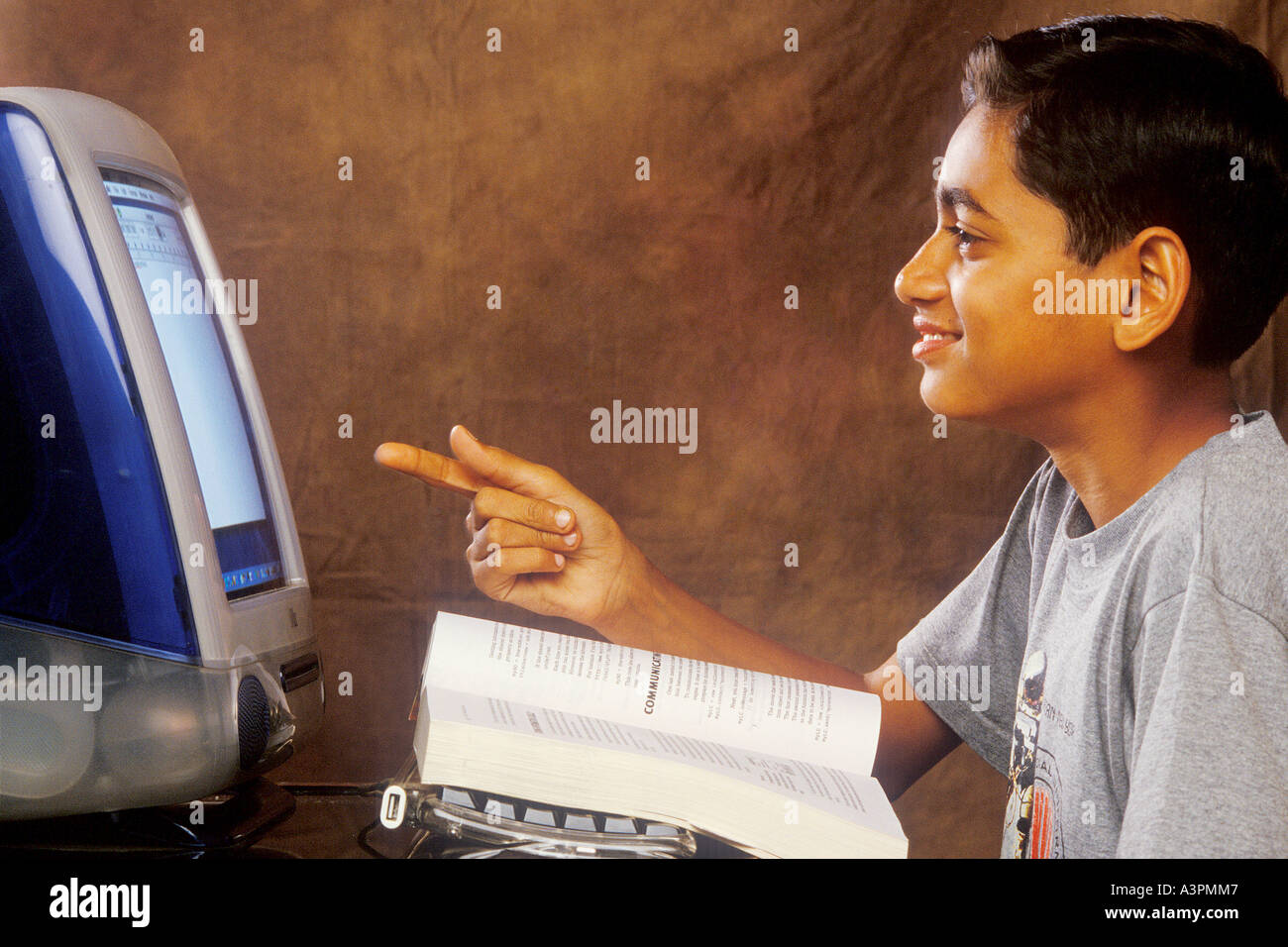 RHS99474 South Asian Indian giovane ragazzo lavorando sul computer alla ricerca di computer con sorriso MR 518 Foto Stock