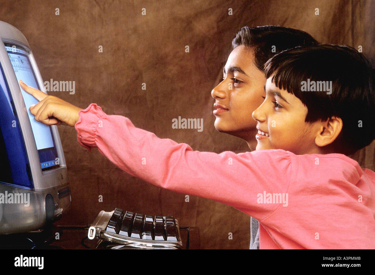 RHS99478 Sud indiano asiatico i bambini che lavorano sul computer guardando verso computer con sorriso MR 518 519 Foto Stock