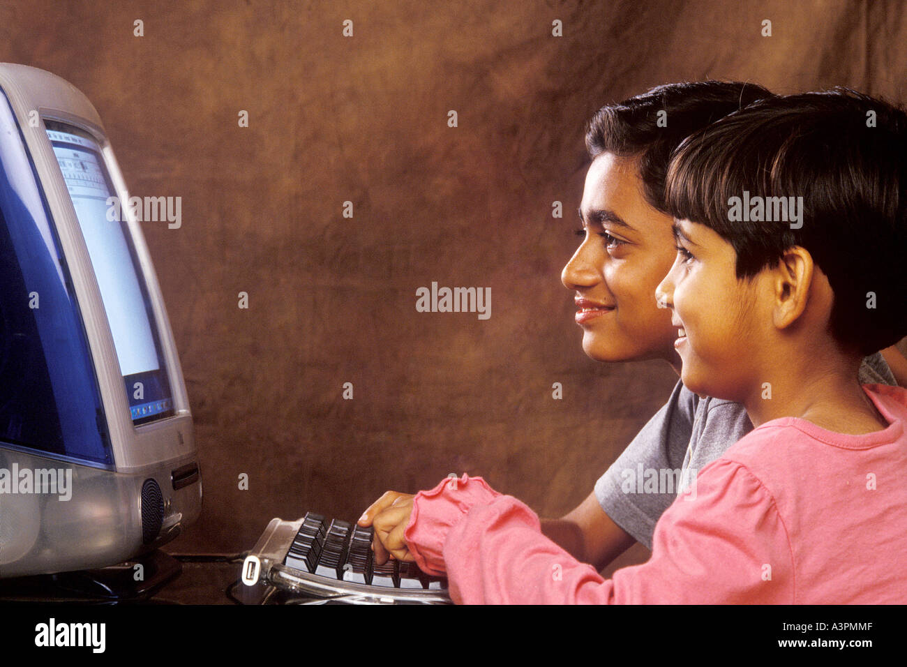 RHS99482 Sud indiano asiatico i bambini che lavorano sul computer guardando verso computer con sorriso MR 518 519 Foto Stock