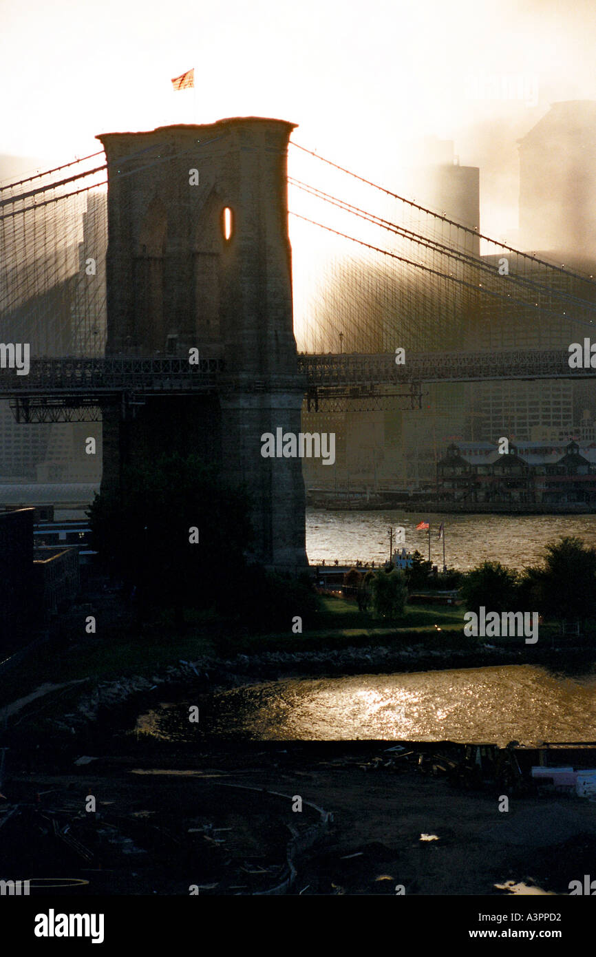 Al tramonto i raggi del fumo attraverso il telaio il pilone est del ponte di Brooklyn dopo gli attacchi terroristici dell'11 settembre 2001 Foto Stock