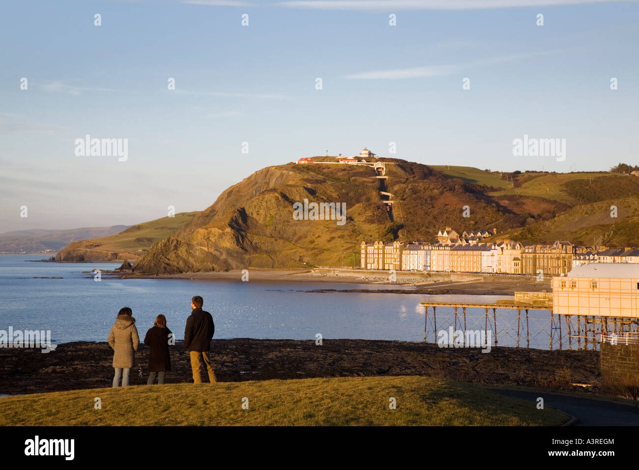 Persone che guardano a vista dal punto di castello affacciato su Cardigan Bay costa lungomare e Constitution Hill Aberystwyth Wales UK Foto Stock
