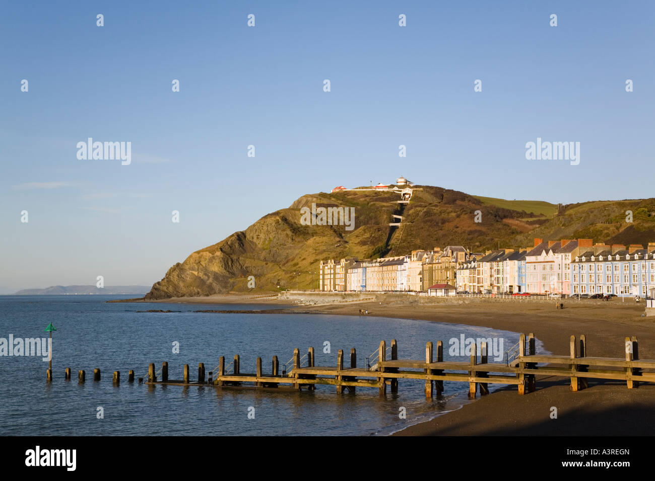 Lungomare vittoriano edifici e pennelli in legno sulla spiaggia del nord nella città balneare di Cardigan Bay. Aberystwyth Ceredigion REGNO UNITO Galles Foto Stock