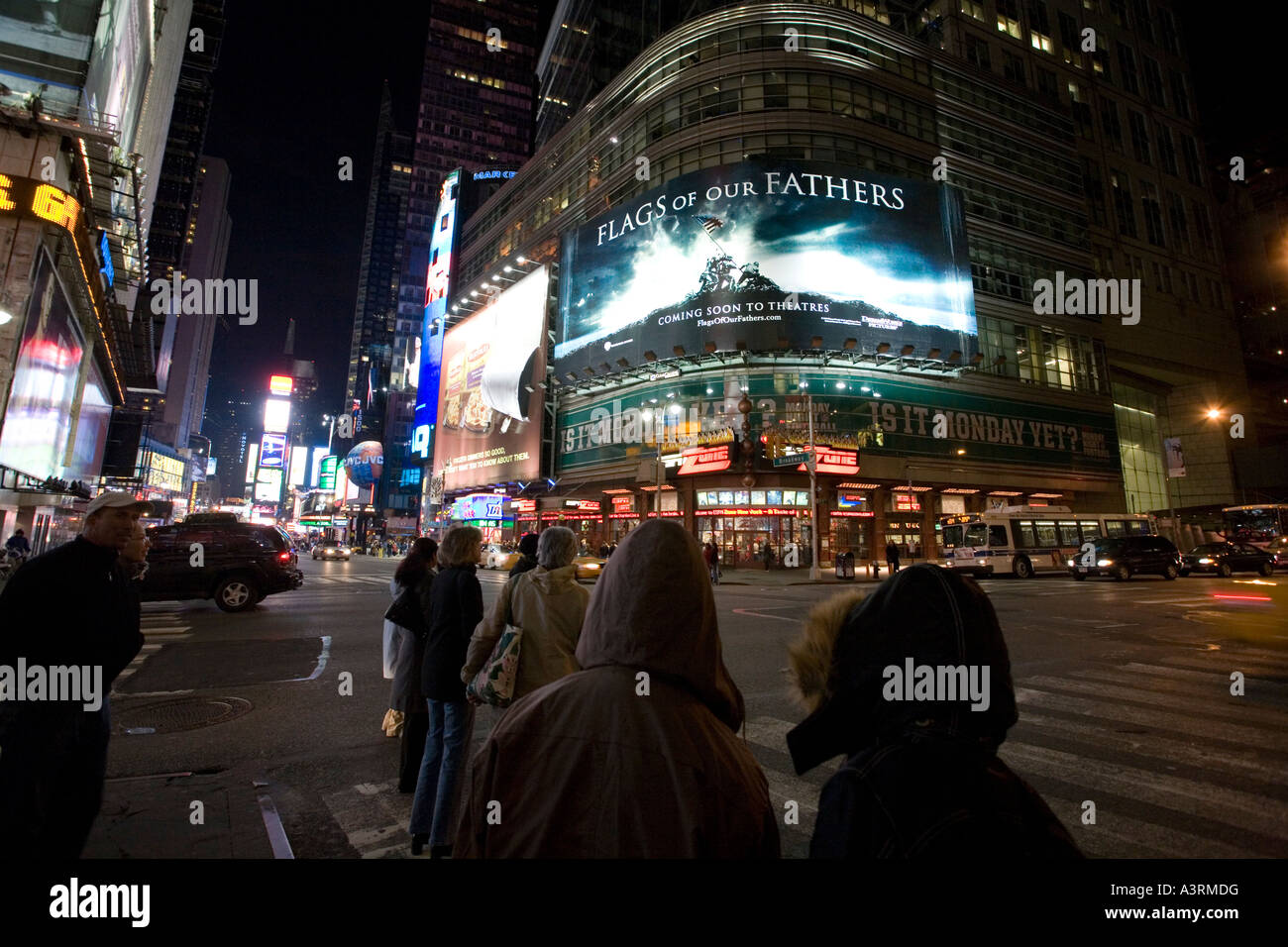 Persone su Times Square di notte NYC un grande tabellone del filmato le bandiere dei nostri padri da Clint Eastwood può essere visto Foto Stock