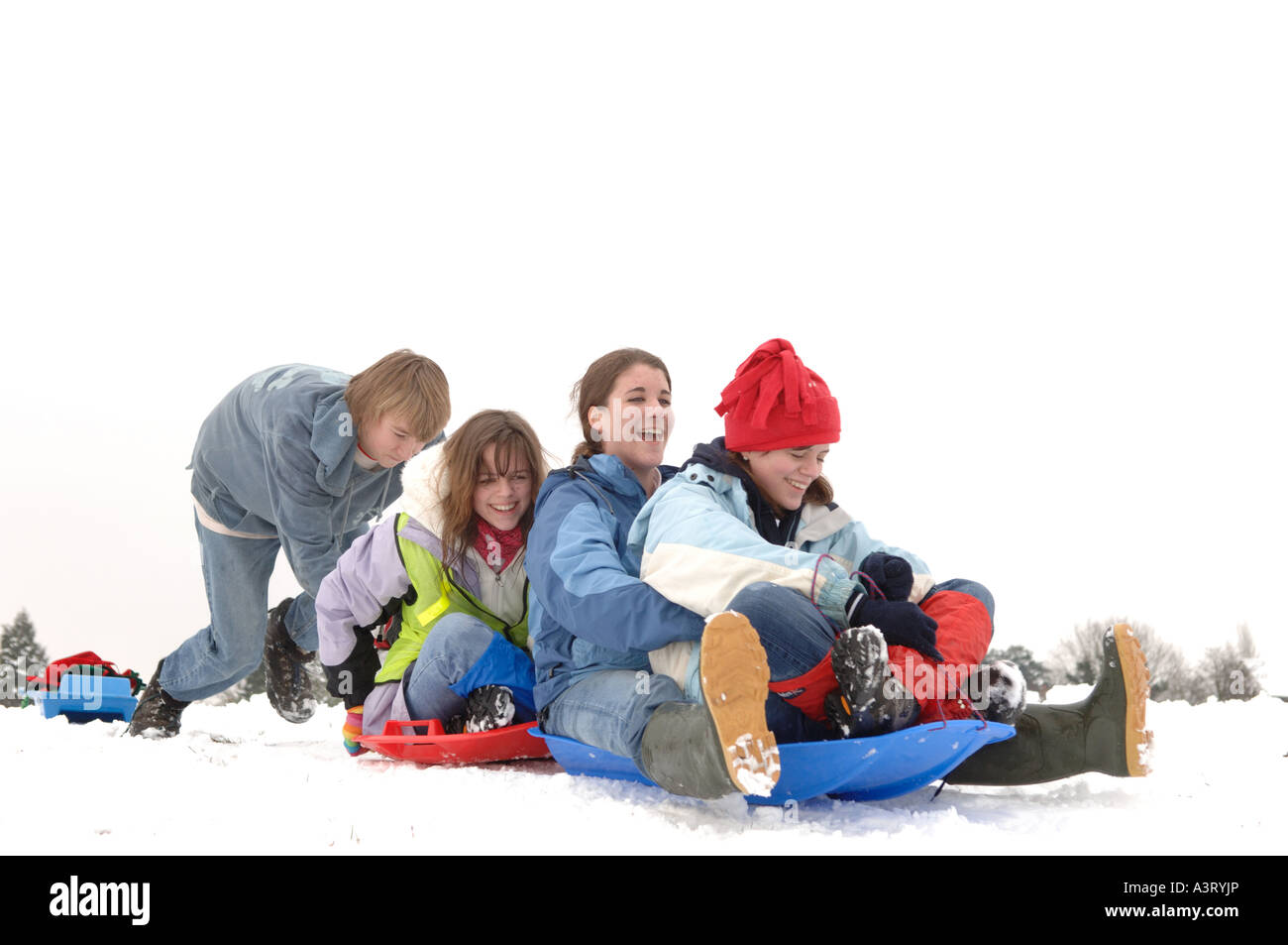 Felice ragazzi giocare nella neve su uno slittino e slitta. Una vacanza stile di vita evento. Buckinghamshire Inghilterra Foto Stock