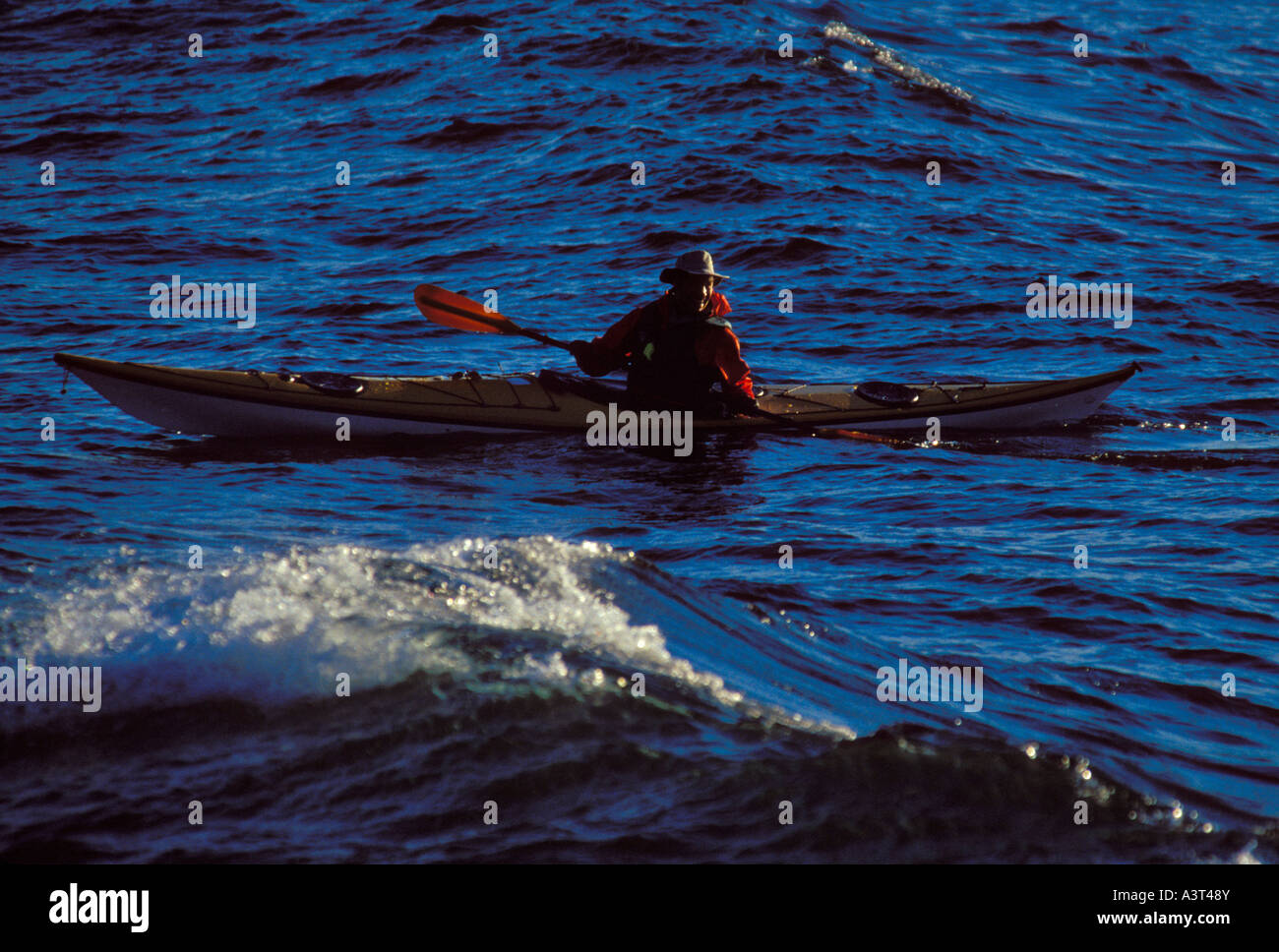 Un KAYAKER RIPRODUCE IN ONDE AL LARGO DELLA COSTA di Presque Isle PARK IN MARQUETTE MICHIGAN Foto Stock