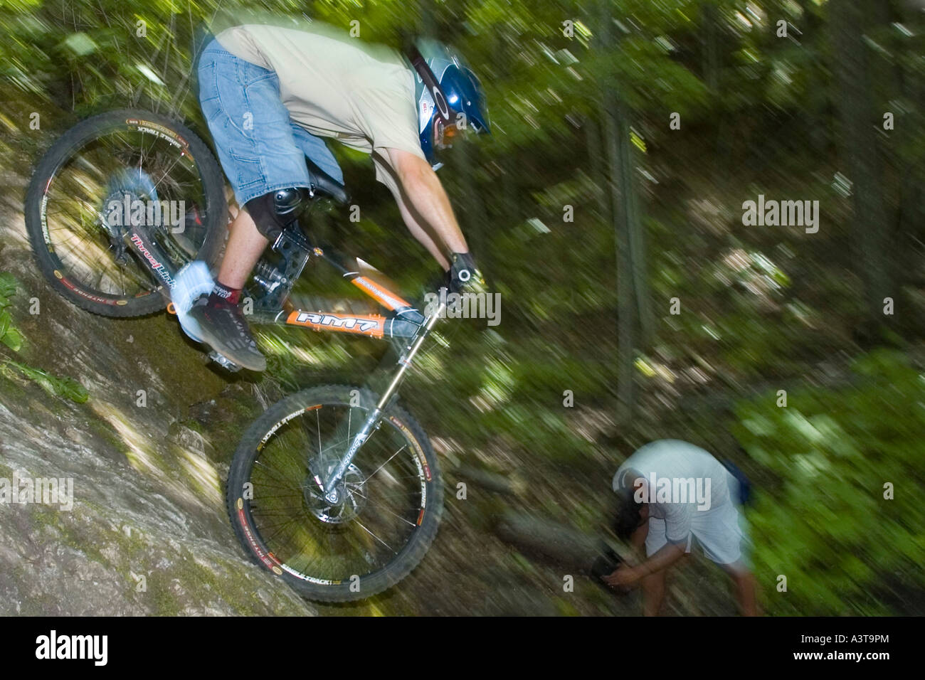 Gli amanti della mountain bike goccia giù il volto di una scogliera mentre il freeride vicino a Marquette Michigan Foto Stock