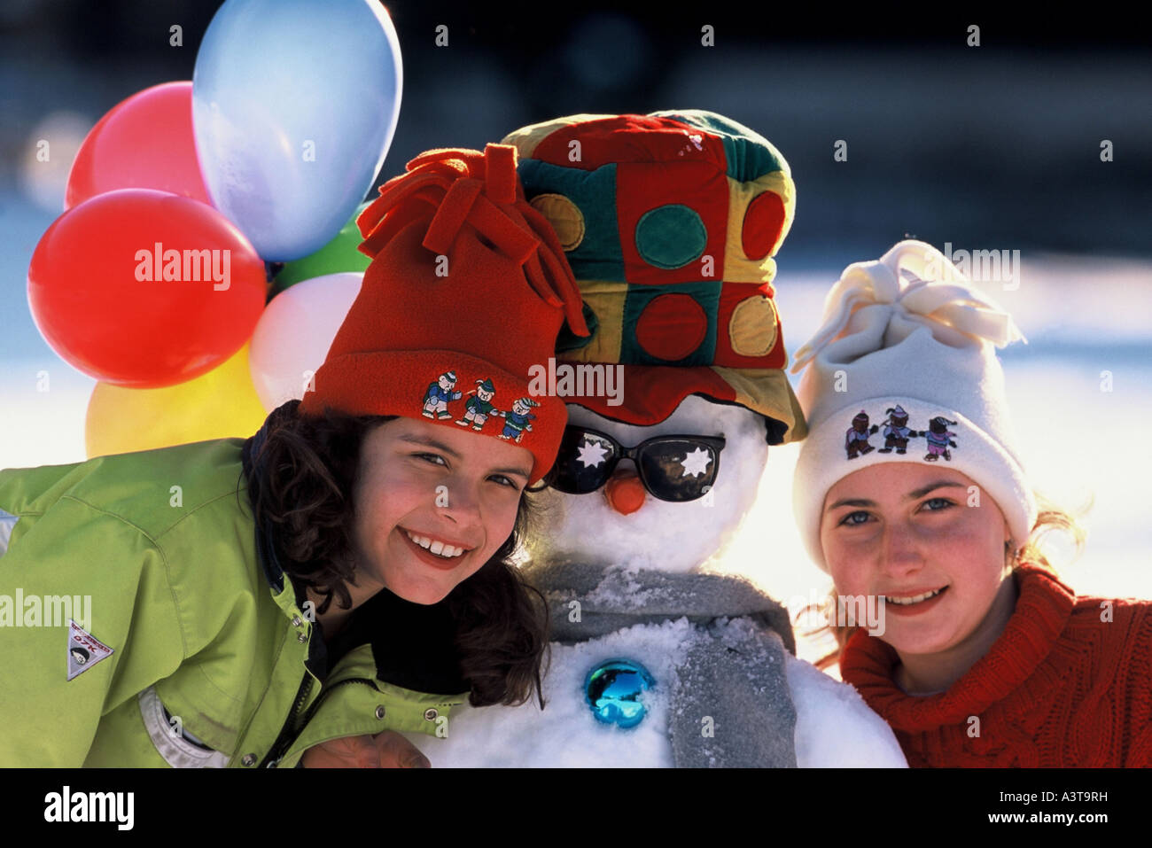 Due giovani ragazze e un pupazzo di neve Foto Stock