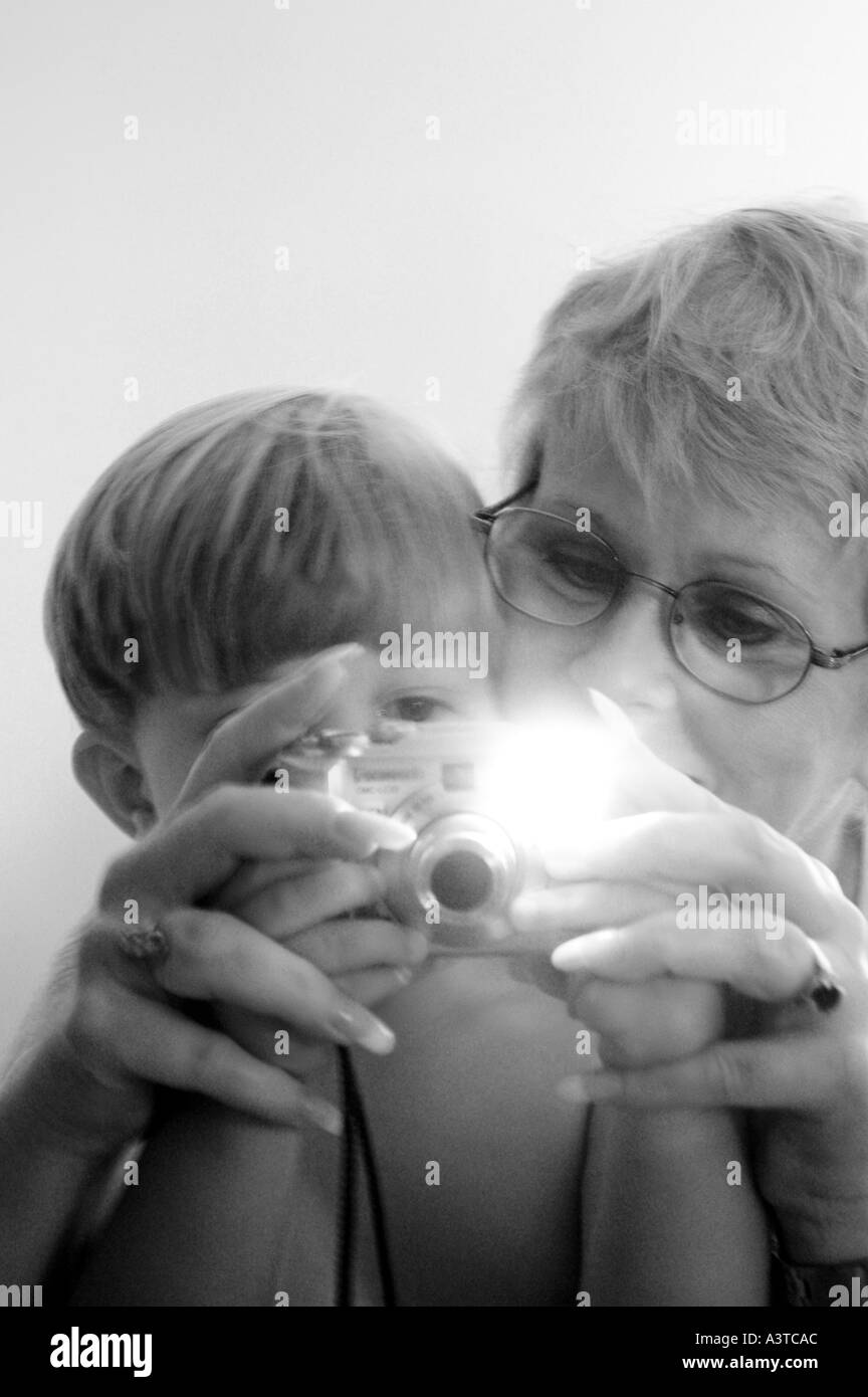 Nonna e ragazzo di scattare una foto con una piccola fotocamera digitale andando flash disattivato Foto Stock