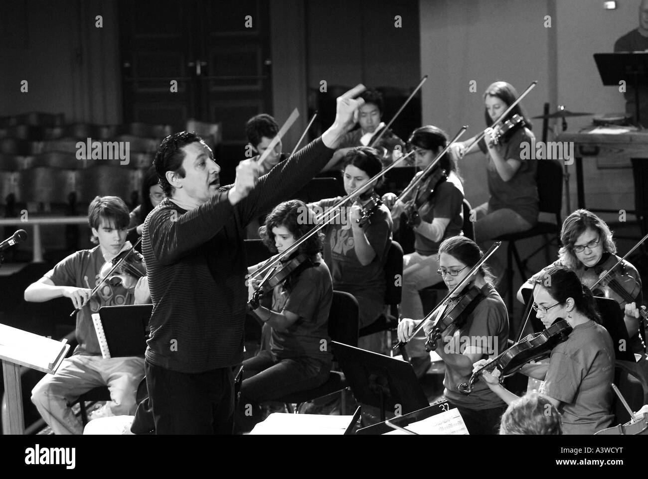Direttore musicale conduce una scuola di alta fascia in pratica per il prossimo concerto conductor Foto Stock