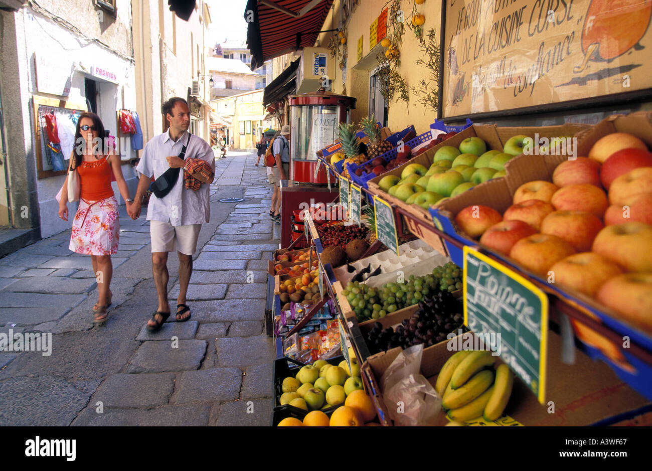 Giovane a piedi da una frutta e verdura stallo in Calvi città vecchia isola di Corsica Francia Foto Stock