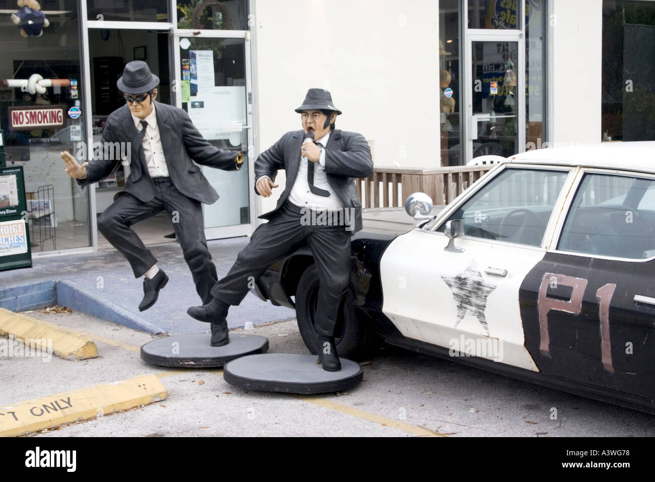 Jake e Elwood al Blues Brothers Cafe di cantare e ballare accanto a auto della polizia. Indian Rocks Beach Florida USA Foto Stock