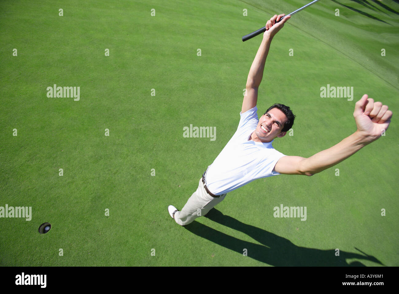 Golfista maschio stringendo i pugni in eccitazione dopo un facendo un putt Foto Stock